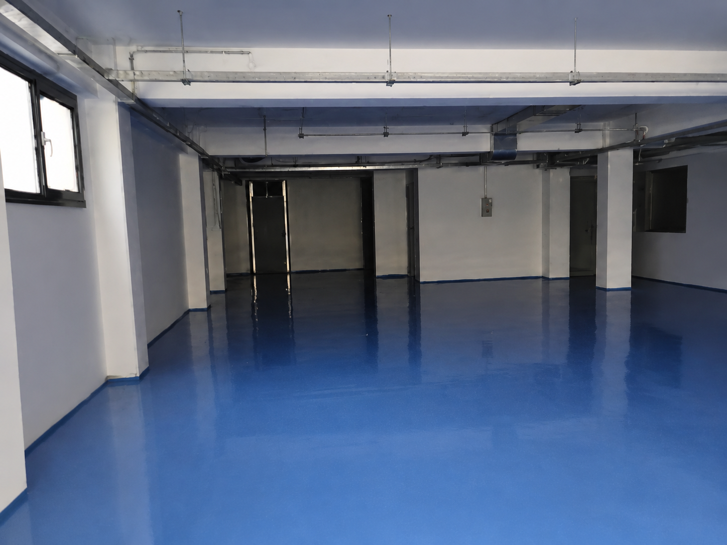 Blauwe polyaspartic vloer in een garage of autobedrijf in Den Haag