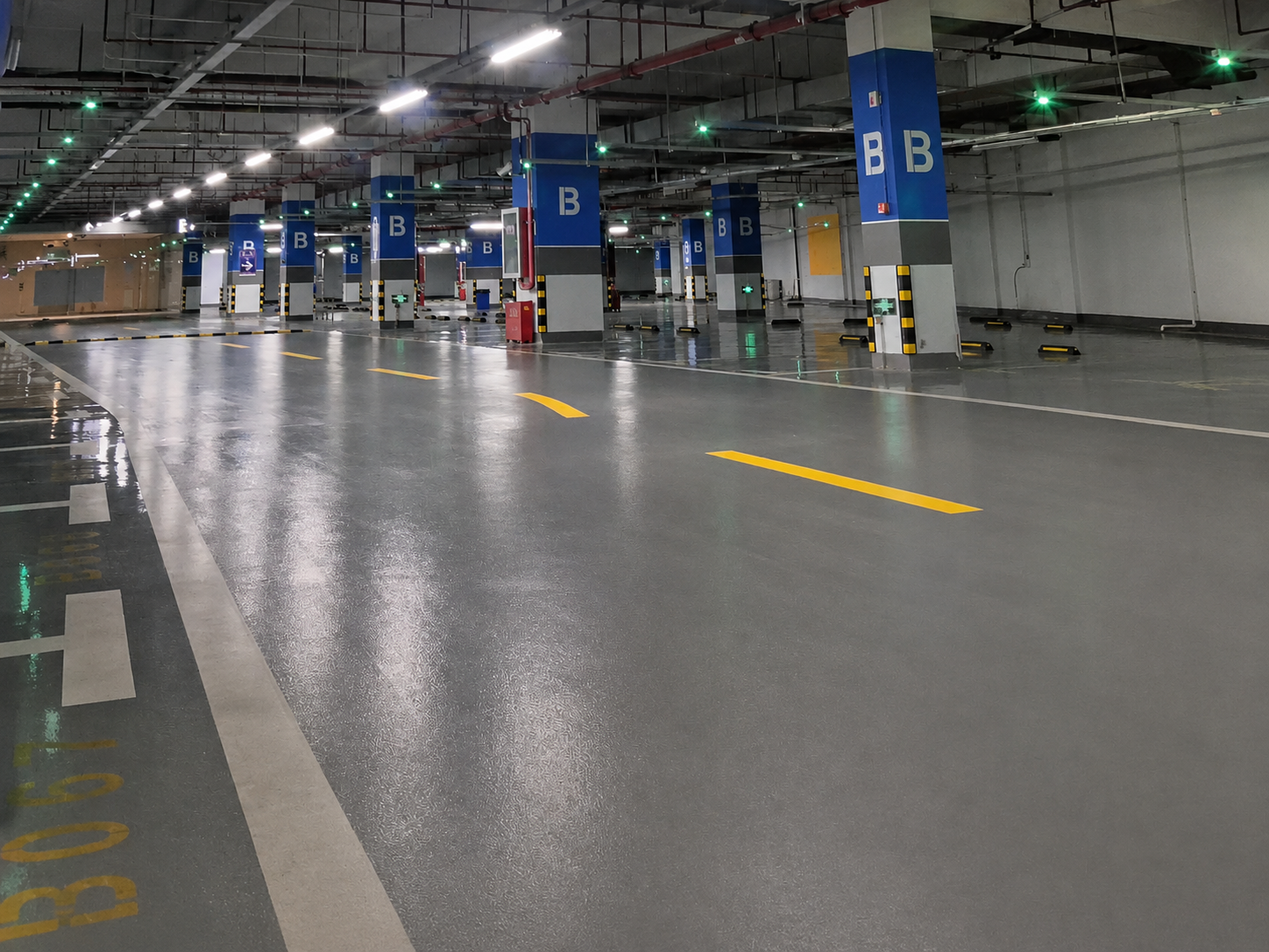 Slijtvaste grijze bedrijfsvloer met rijbanen in een parkeergarage